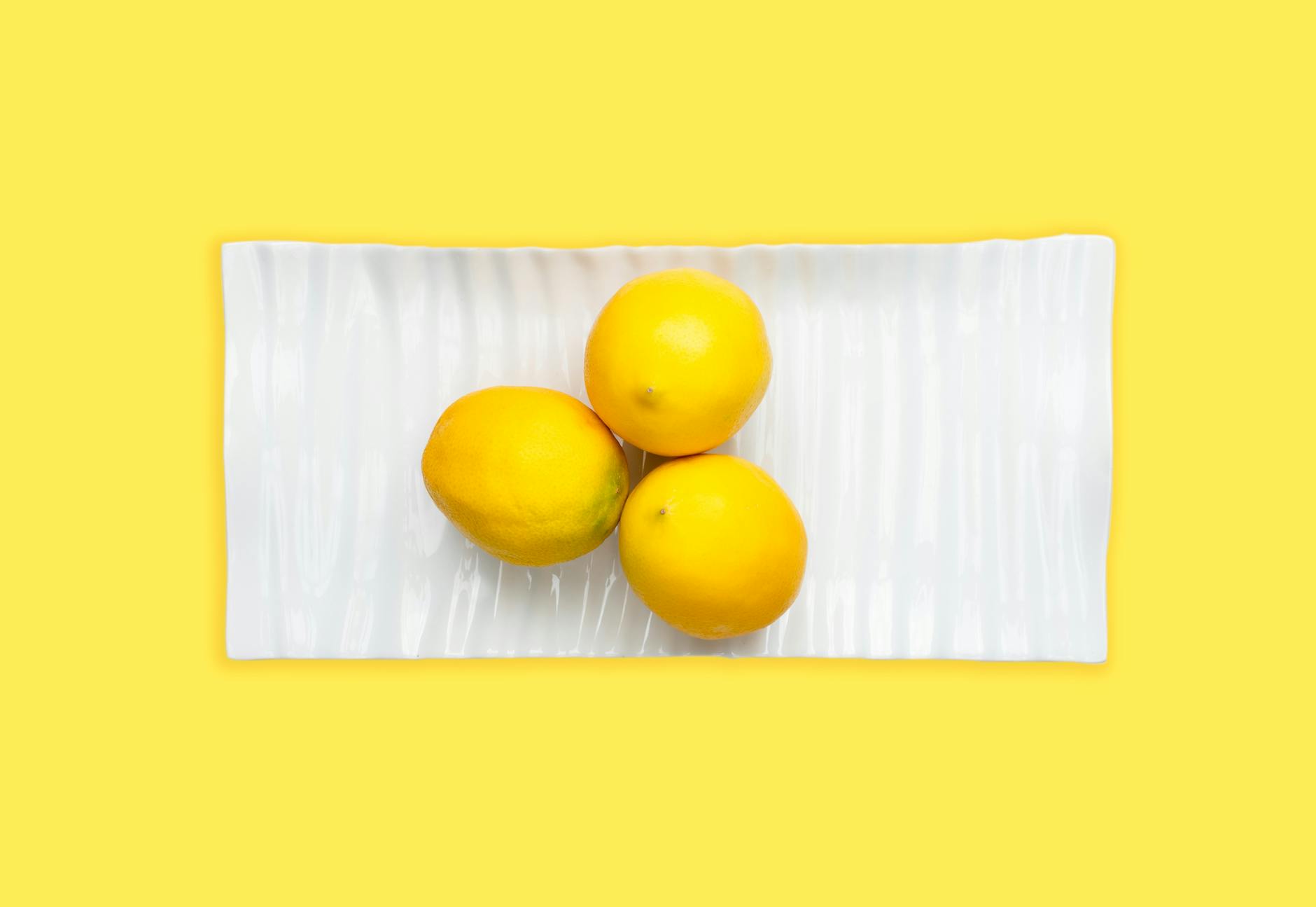 Three fresh lemons arranged on white background emphasizing natural citrus appeal and vitality