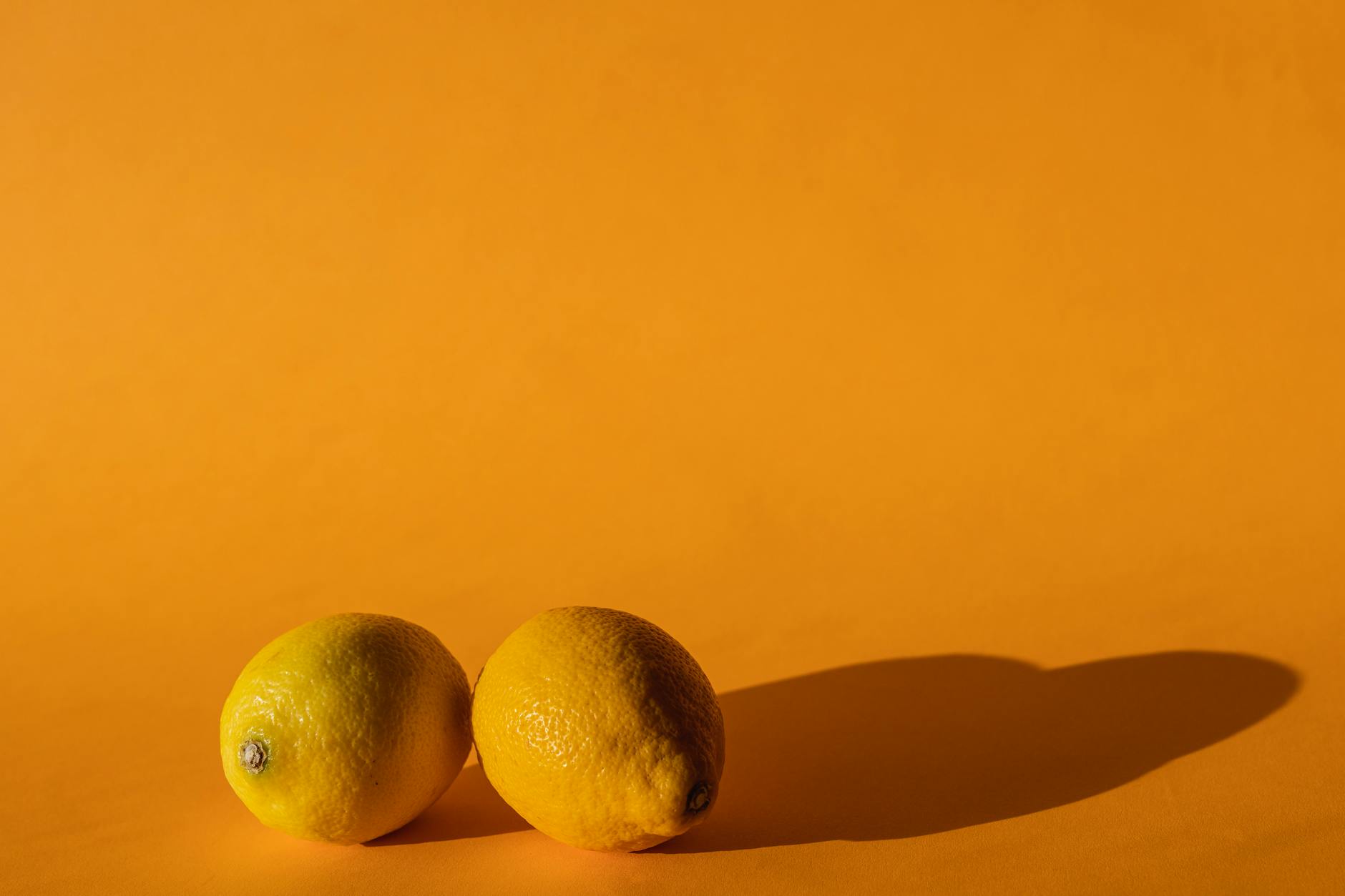 Fresh ripe lemons on a bright yellow background, symbolizing the return of vitality and sensuality after depression